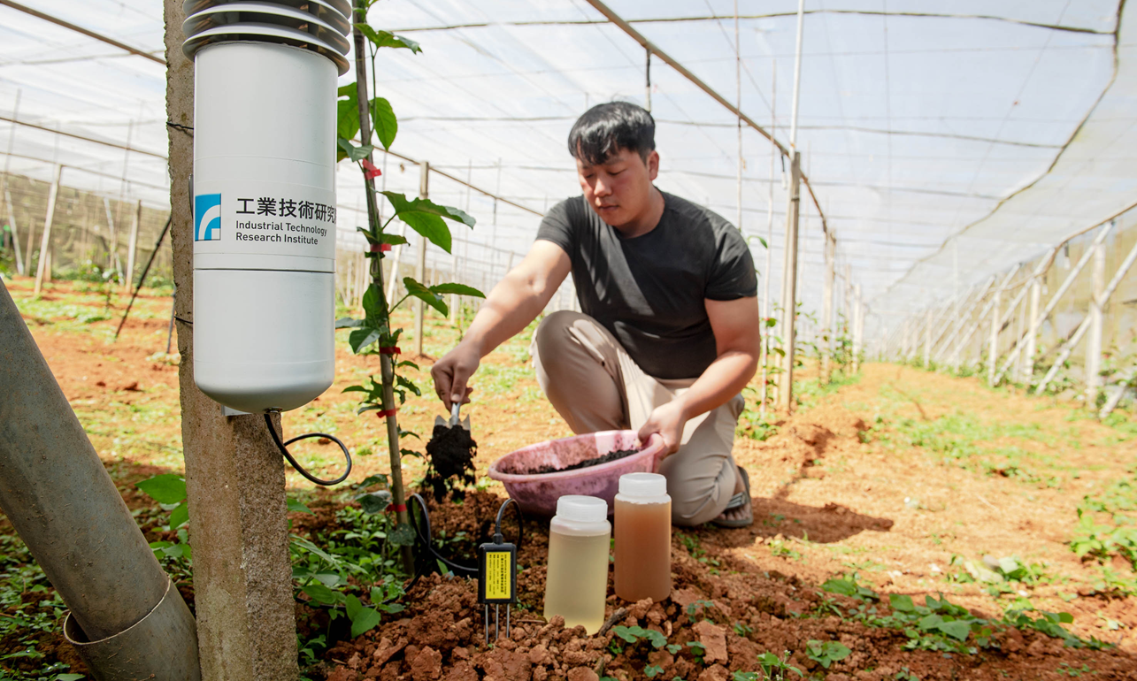 在工研院ICM系統指引下,青農白政益蹲身田間混拌經改質的生物炭,打造適合益菌定居的好土壤。